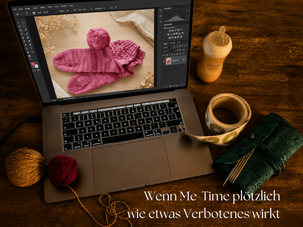Laptop mit Strickprojekt, Babyflasche und Wollzubehör zwischen Alltag, Arbeit und fehlender Me-Time