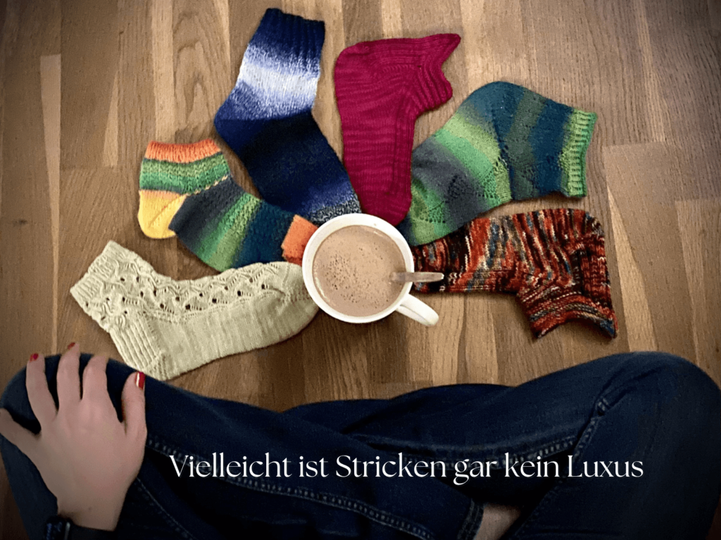 Bunte handgestrickte Socken und eine Tasse Kaffee als entspannter Strickmoment im Alltag